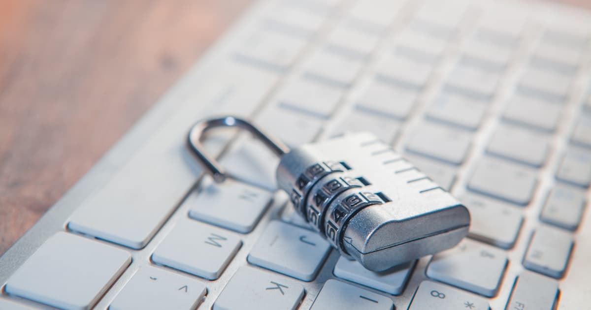 A combination padlock with numbered dials sitting on a computer keyboard