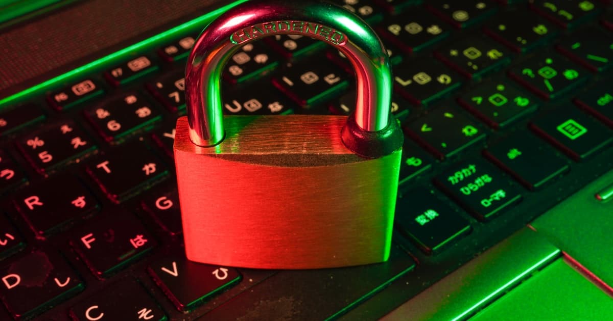 A metal padlock resting on a backlit laptop keyboard